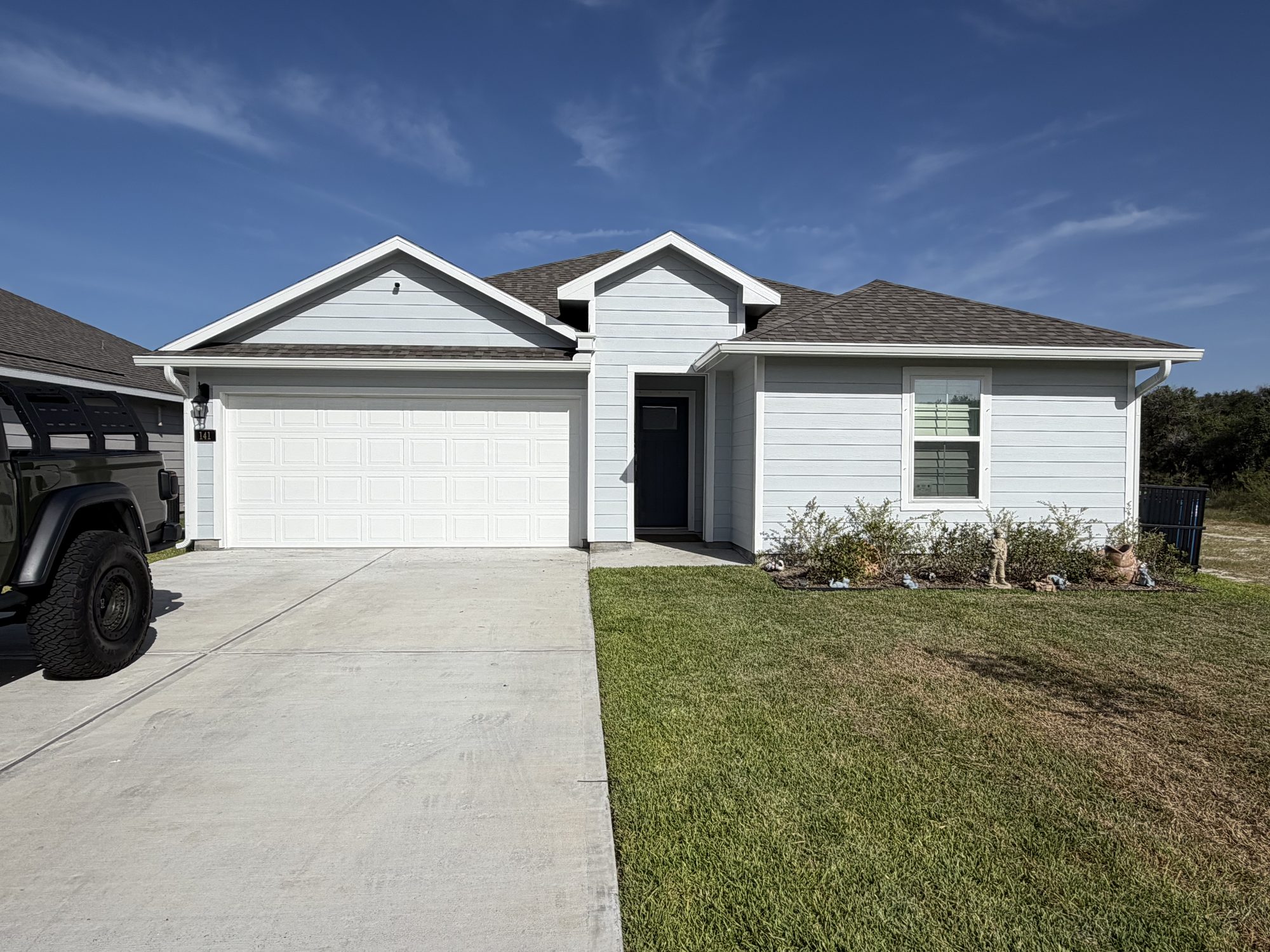 Light gray siding home with new seamless gutters near Rockport and Aransas Pass, by J Seamless Gutters