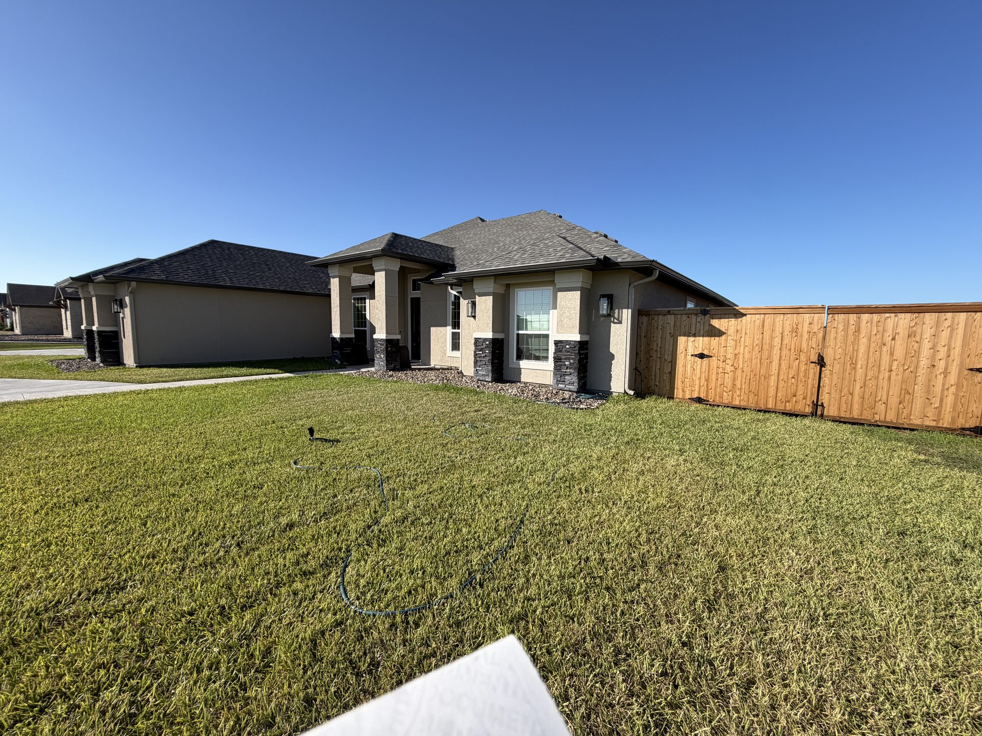 Beige stucco new-build with a continuous seamless gutter run in the Coastal Bend