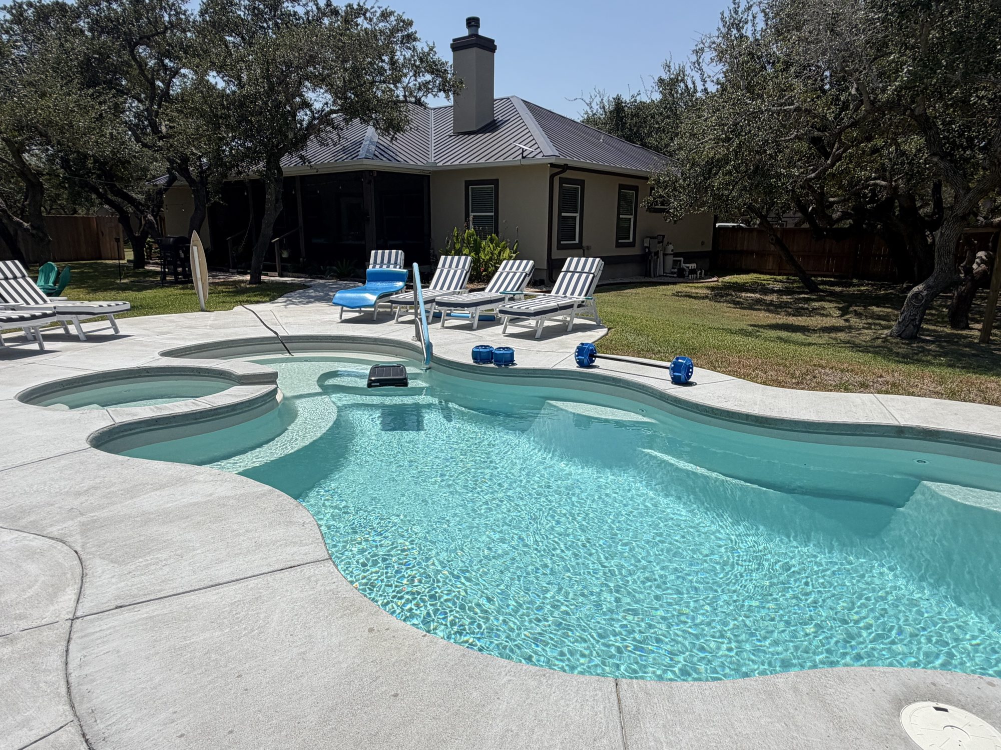 Pool behind a tan ranch with seamless gutters in the Rockport–Aransas area