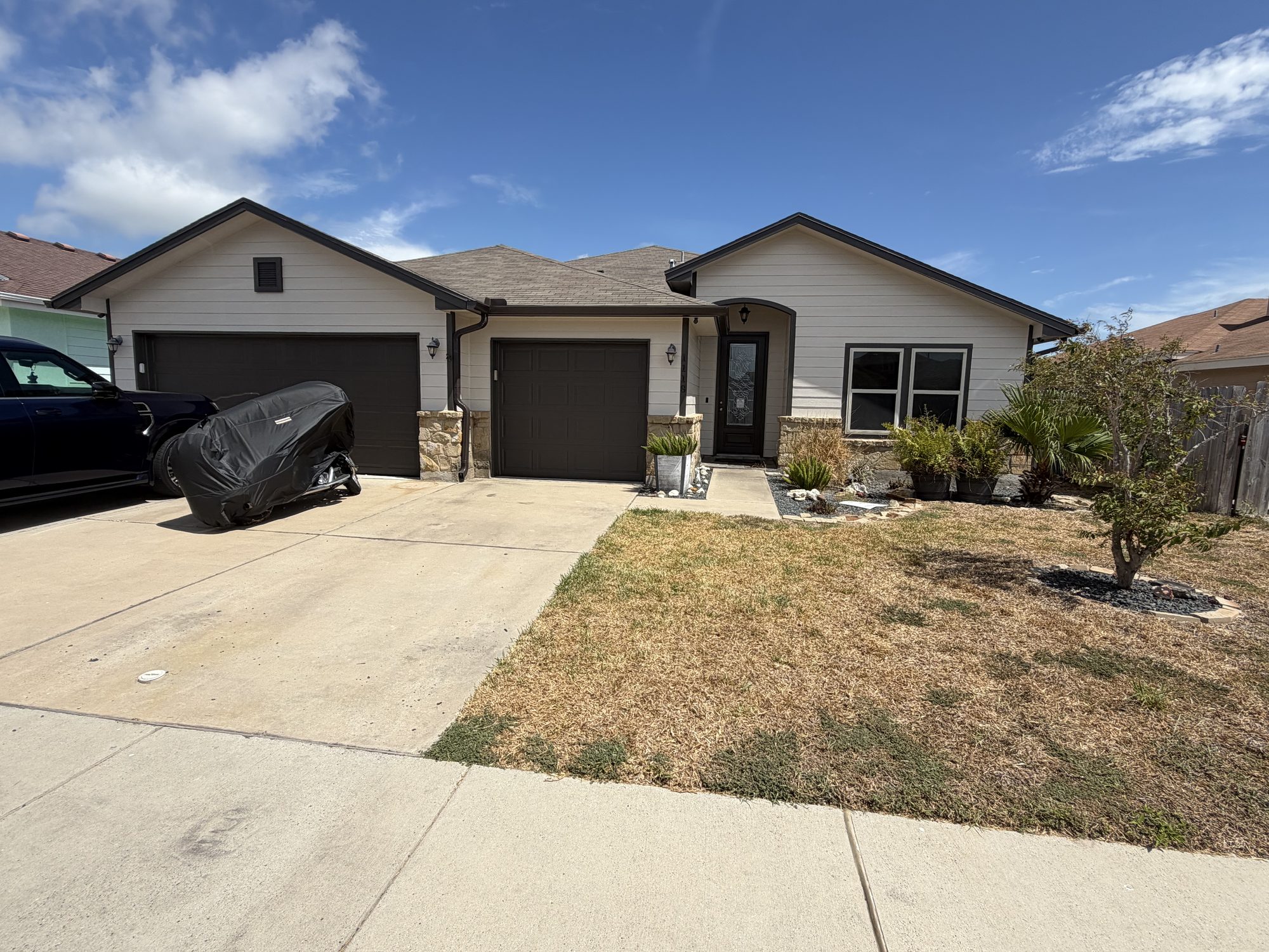 Cream ranch with brown garage doors and seamless gutters in the Corpus Christi area